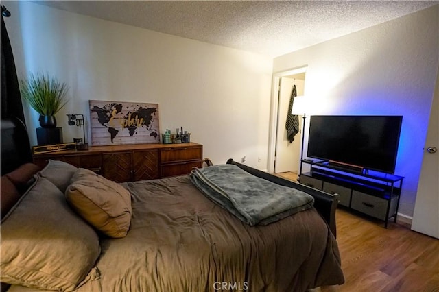 bedroom featuring hardwood / wood-style flooring and a textured ceiling