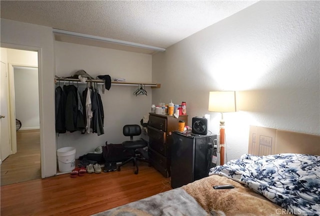 bedroom featuring hardwood / wood-style flooring and a textured ceiling