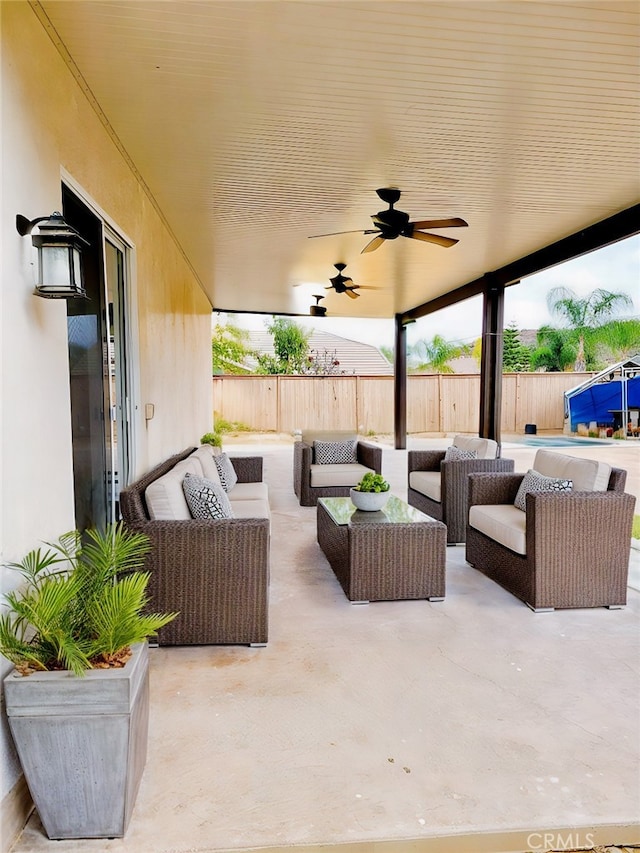 view of patio with a ceiling fan, fence, and an outdoor living space