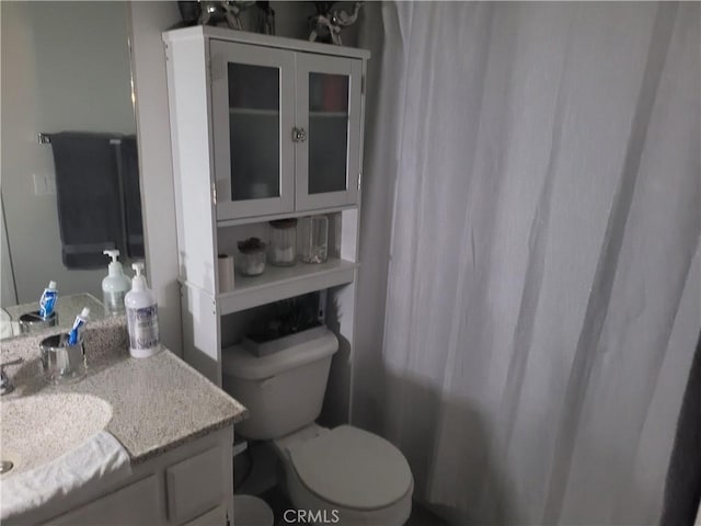 full bath featuring a shower with curtain, vanity, and toilet