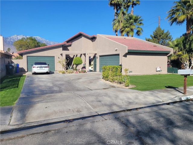 view of front of home featuring a garage, a front yard, driveway, and stucco siding