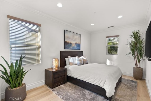 bedroom featuring light wood-type flooring and crown molding