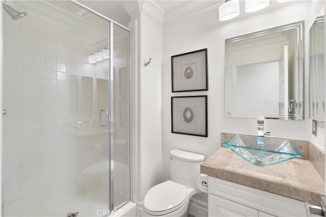 bathroom with ornamental molding, vanity, toilet, and walk in shower