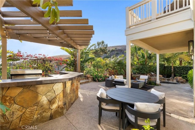 view of patio / terrace featuring an outdoor bar, a pergola, a balcony, and exterior kitchen