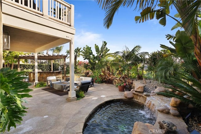 view of patio with a pergola, a balcony, a bar, and an outdoor fire pit