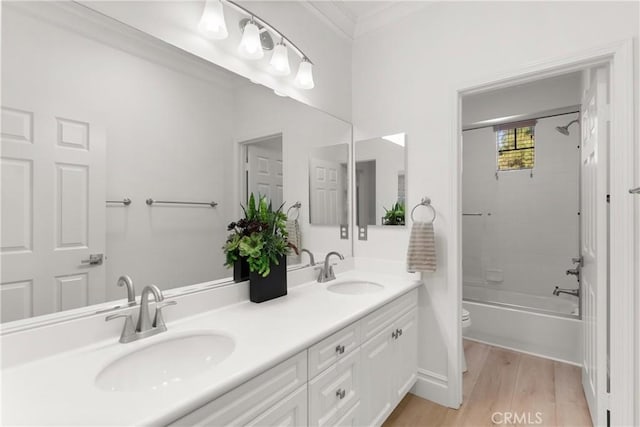 full bathroom featuring vanity, toilet, hardwood / wood-style flooring,  shower combination, and ornamental molding