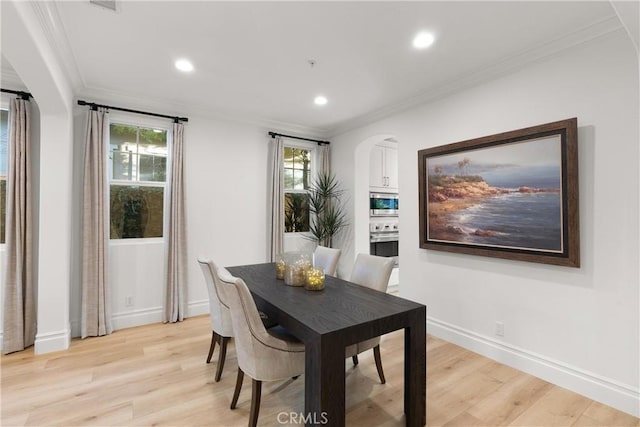 dining area featuring ornamental molding and light wood-type flooring