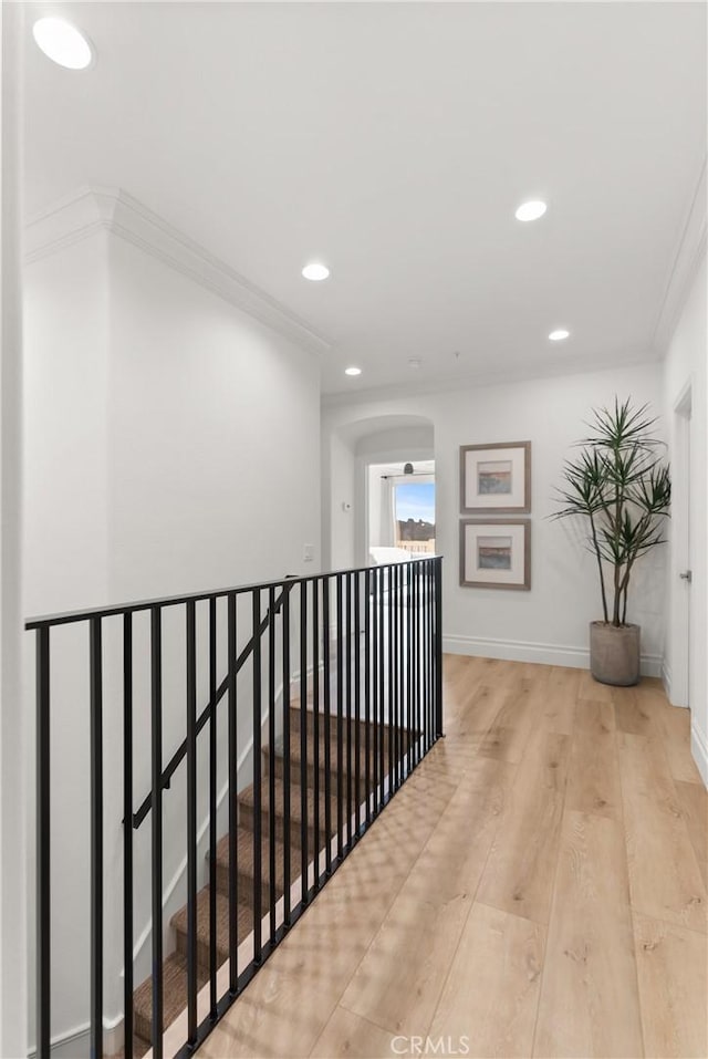 hall featuring light wood-type flooring and crown molding