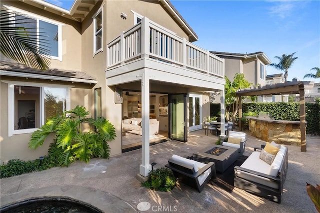 back of property featuring a patio, a fire pit, a balcony, and a bar