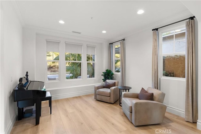 living area featuring light hardwood / wood-style flooring and crown molding