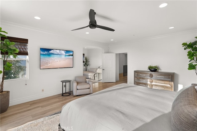 bedroom with ceiling fan, ornamental molding, and light wood-type flooring