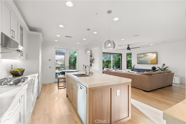 kitchen with a center island with sink, sink, white cabinetry, dishwasher, and decorative light fixtures