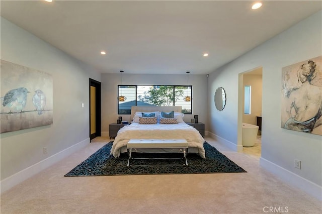 bedroom featuring light colored carpet and ensuite bath