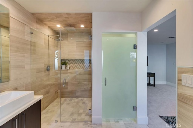 bathroom with vanity and a shower with door