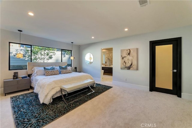 bedroom featuring connected bathroom and light carpet