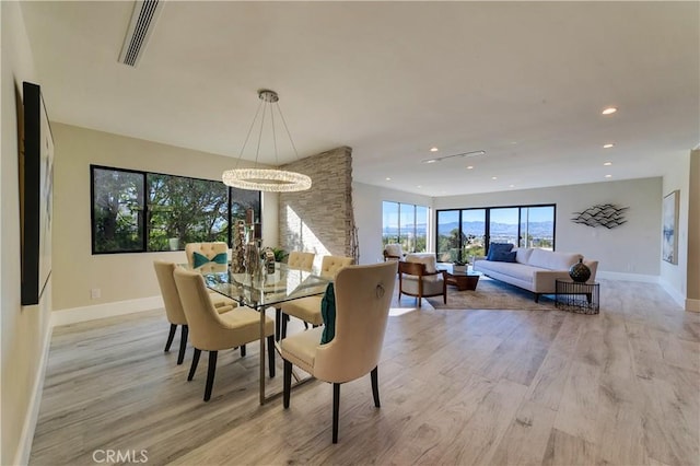 dining space featuring light hardwood / wood-style flooring and a notable chandelier