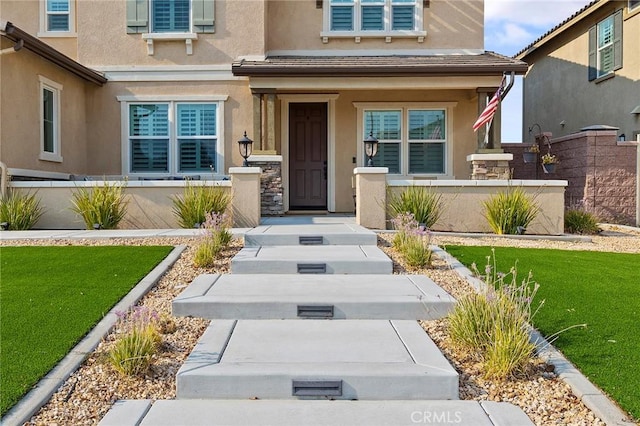 entrance to property featuring a lawn