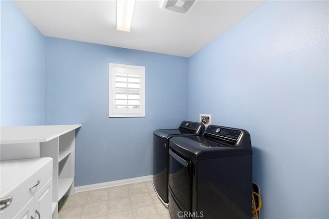 washroom with cabinets and washing machine and clothes dryer