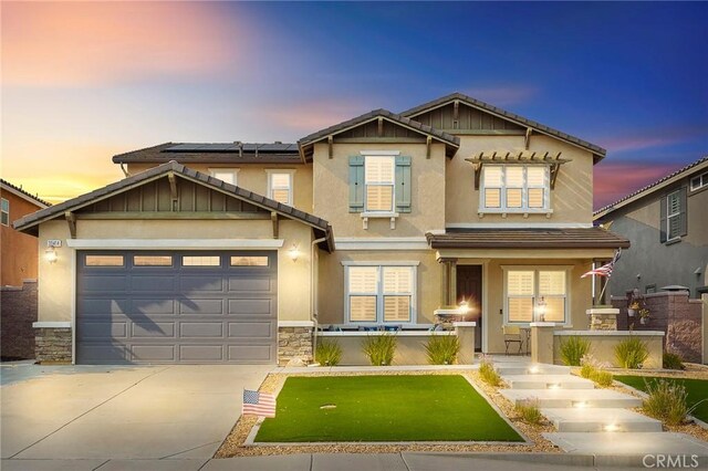 craftsman inspired home with a porch, a garage, and solar panels