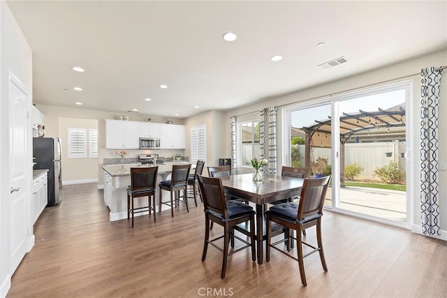 dining space featuring a healthy amount of sunlight and light wood-type flooring