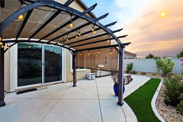 patio terrace at dusk featuring a pergola