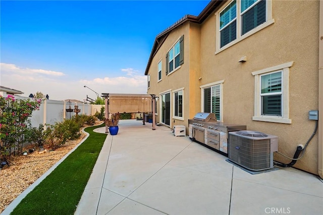 exterior space with central AC unit, a pergola, and exterior kitchen