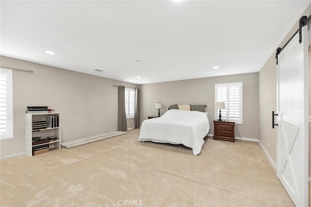 carpeted bedroom featuring multiple windows and a barn door