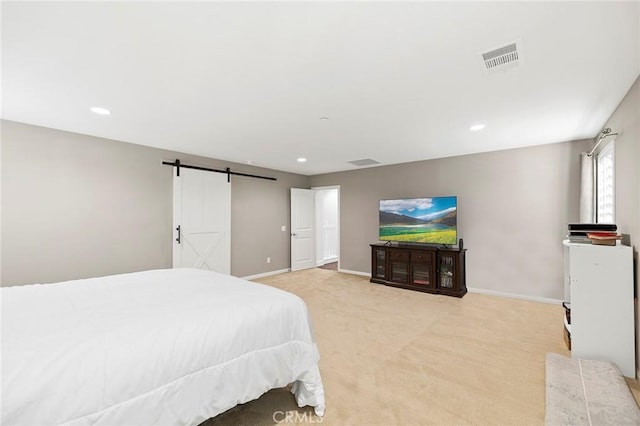 carpeted bedroom featuring a barn door