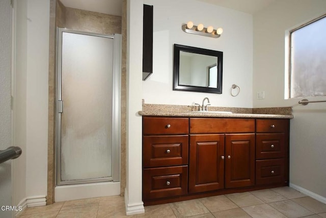 bathroom with tile patterned floors, vanity, and a shower with door