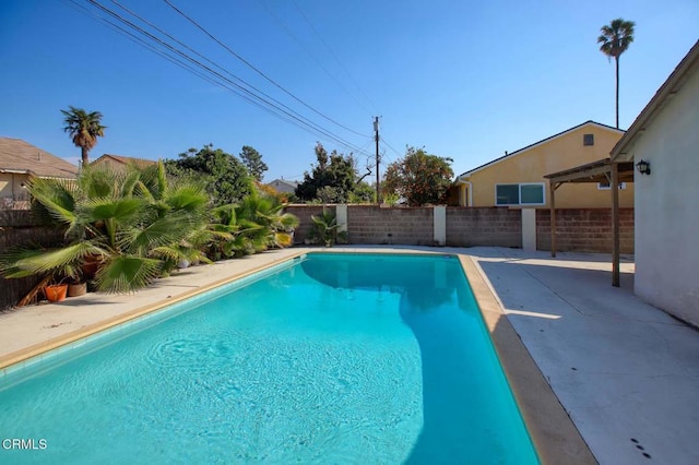 view of swimming pool featuring a fenced in pool, a fenced backyard, and a patio