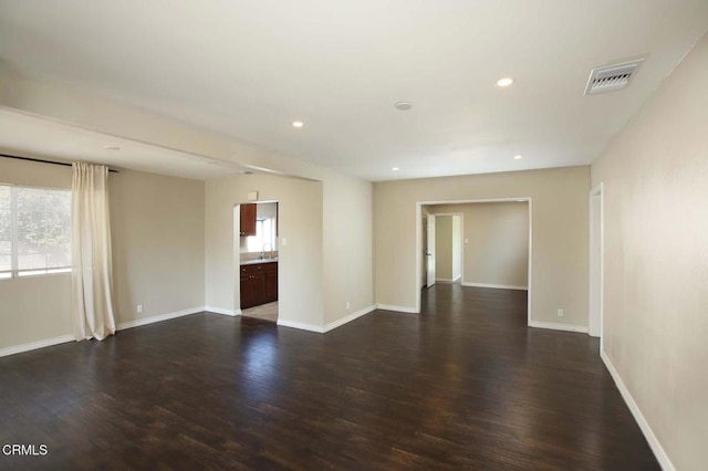 spare room featuring dark wood-type flooring, recessed lighting, visible vents, and baseboards