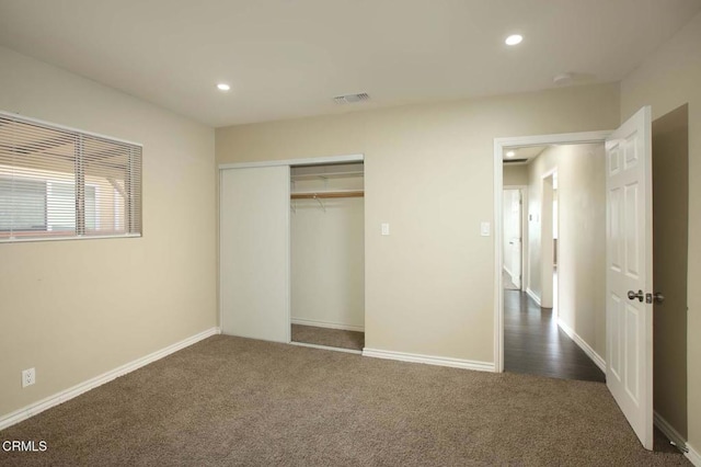 unfurnished bedroom with baseboards, dark carpet, and recessed lighting