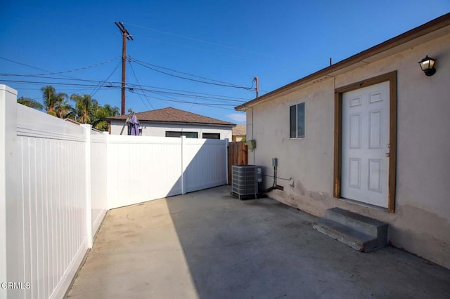 view of patio featuring entry steps, fence, and central AC unit