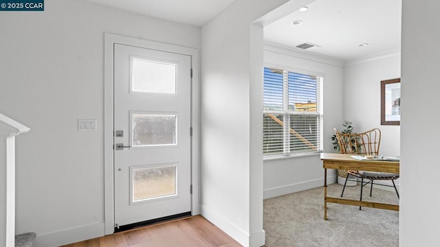 foyer entrance featuring ornamental molding and light hardwood / wood-style floors