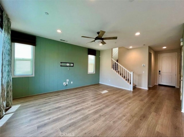 unfurnished living room with ceiling fan and light hardwood / wood-style flooring