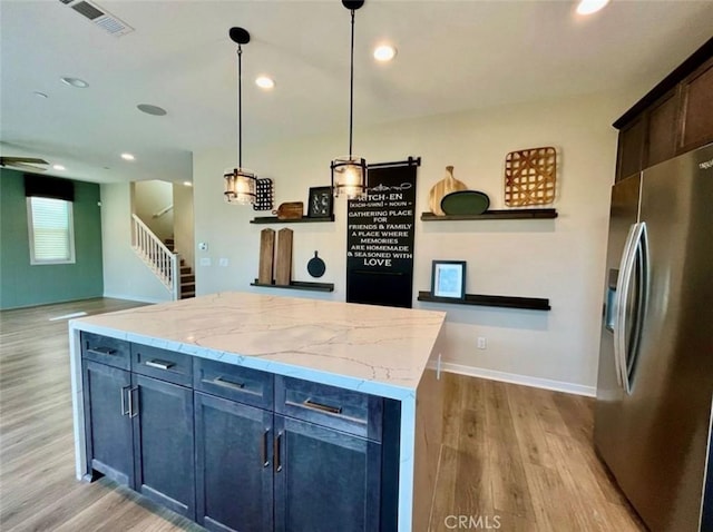 kitchen featuring a kitchen island, pendant lighting, stainless steel fridge, and light wood-type flooring