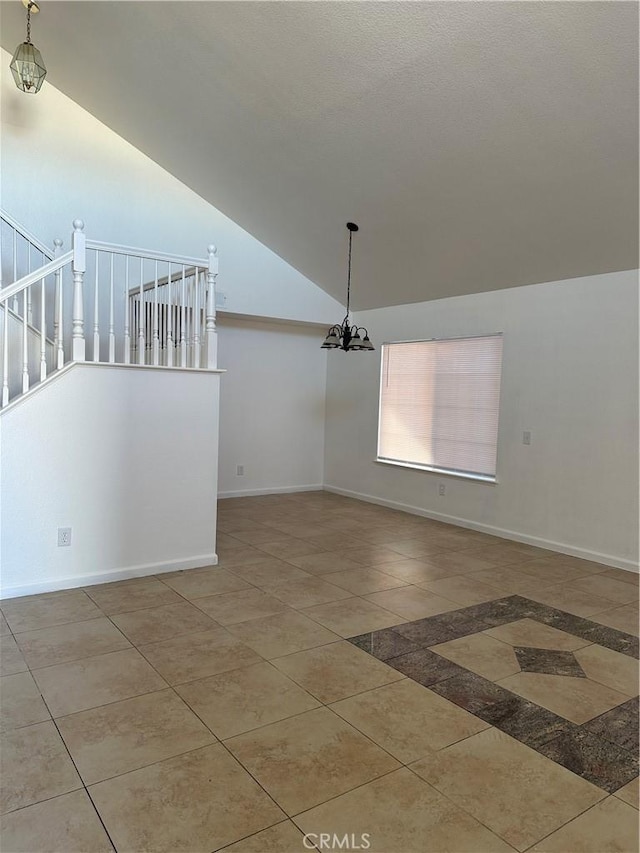 tiled empty room with vaulted ceiling and a notable chandelier