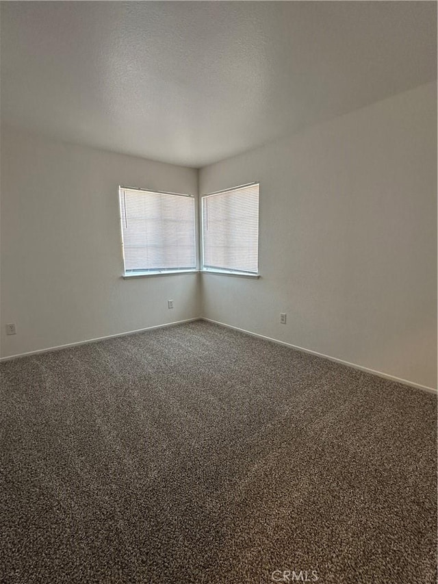 carpeted empty room with a textured ceiling