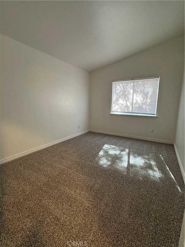 carpeted spare room featuring lofted ceiling