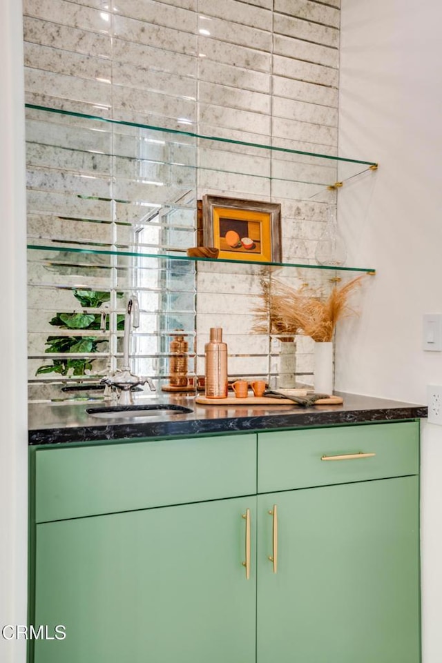 bar featuring sink and green cabinets