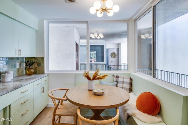 dining room with breakfast area, light hardwood / wood-style floors, and a notable chandelier