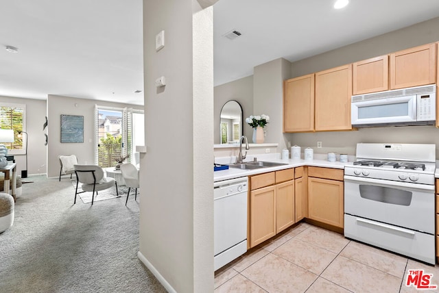 kitchen with light brown cabinetry, sink, white appliances, and light colored carpet