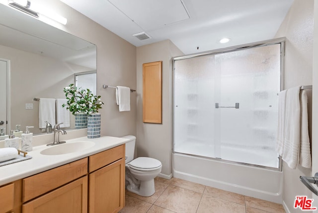 full bathroom featuring tile patterned flooring, vanity, toilet, and combined bath / shower with glass door