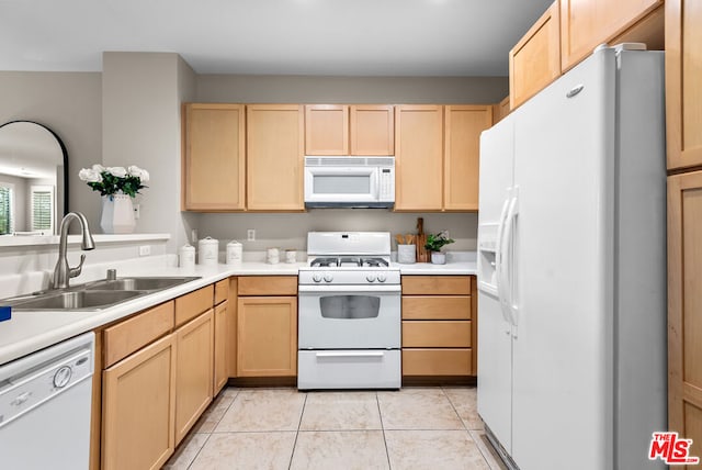 kitchen with sink, white appliances, light tile patterned floors, and light brown cabinets