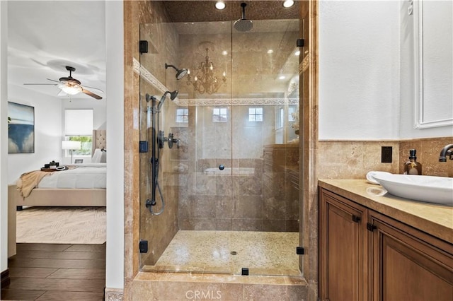 bathroom with hardwood / wood-style flooring, vanity, ceiling fan, and a shower with shower door