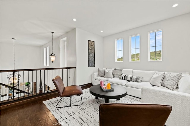 living room featuring an inviting chandelier and dark hardwood / wood-style flooring