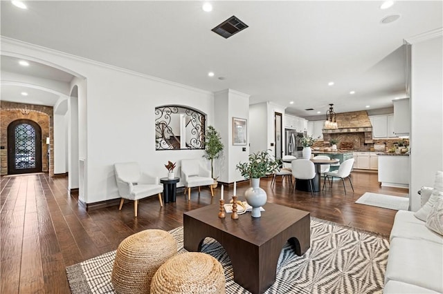 living room with dark wood-type flooring and ornamental molding