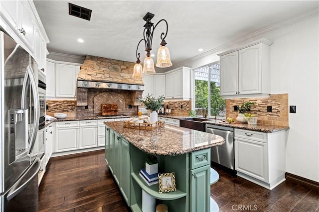 kitchen featuring pendant lighting, white cabinetry, custom exhaust hood, a center island, and stainless steel appliances