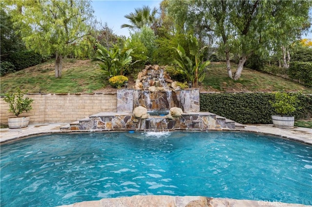 view of swimming pool with pool water feature