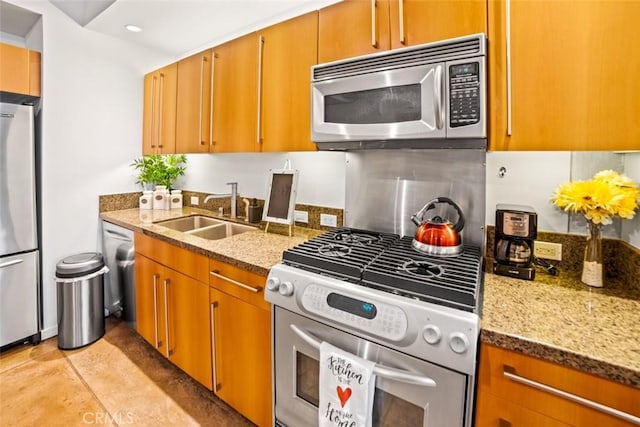 kitchen with tasteful backsplash, stone countertops, appliances with stainless steel finishes, and sink